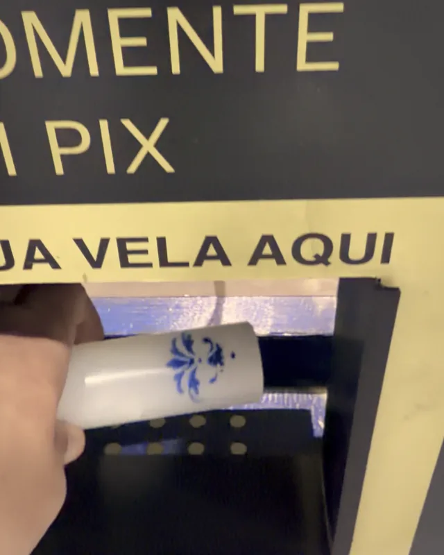 Mão retirando a vela da abertura “Retire sua vela aqui”